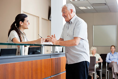 image of medical office receptionist talking with a patient